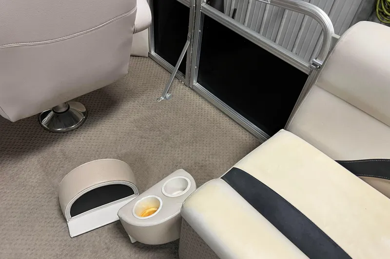 Slide: The Image of Interior of 2014 Avalon Grand Island 2485 QF with beige seating and cup holders. - 24