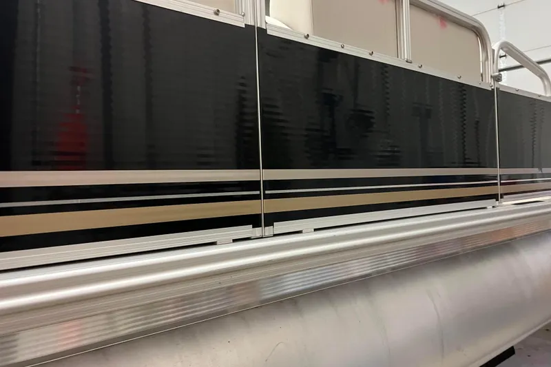 Slide: The Image of 2014 Avalon Grand Island 2485 QF pontoon boat with sleek black and silver design. - 32