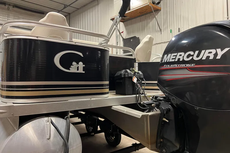 Slide: The Image of 2014 Avalon Grand Island 2485 QF pontoon boat with Mercury FourStroke engine in a garage. - 5