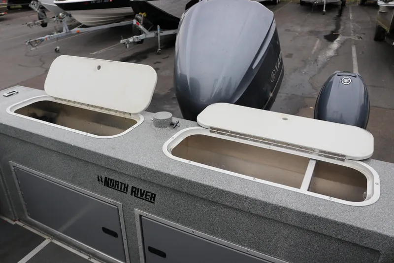 Slide: The Image of 2022 North River Osprey boat with open storage compartments and Yamaha outboard motors. - 19