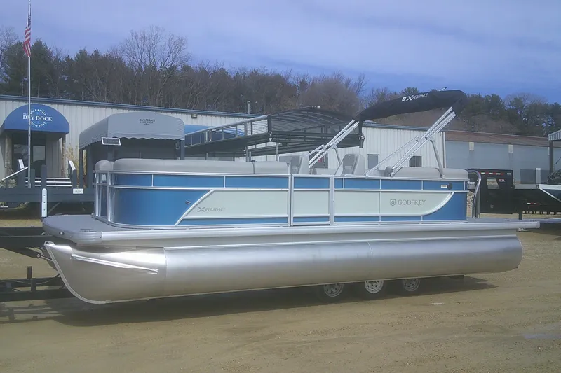 The Image of 2026 Godfrey EX 2286 SBX pontoon boat on trailer, parked outdoors. - 1