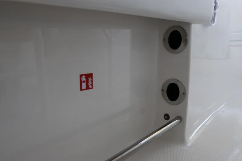 Slide: The Image of 2026 Robalo R202 Explorer boat interior with fire extinguisher symbol and rod holders. - 16