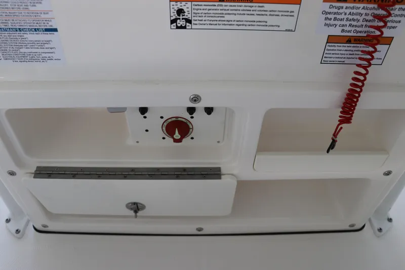 Slide: The Image of Control panel of 2026 Robalo R202 Explorer boat with safety warnings and red coiled cord. - 26