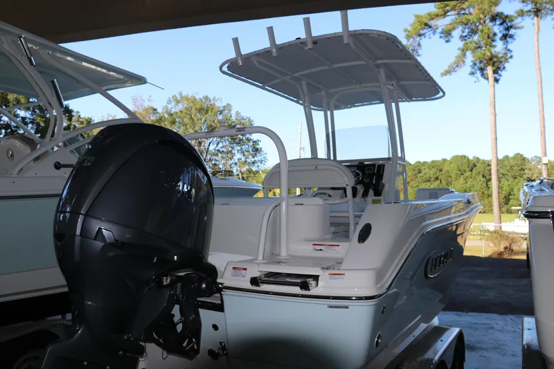 Slide: The Image of 2026 Robalo R202 Explorer boat with outboard motor, parked under shelter. - 6