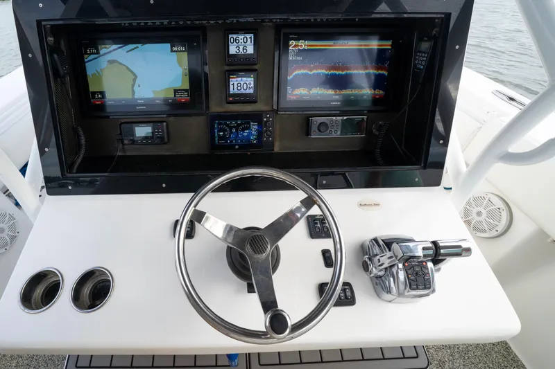 Slide: The Image of Control panel of a 2012 SeaHunter 37 Tournament boat with navigation screens and steering wheel. - 3
