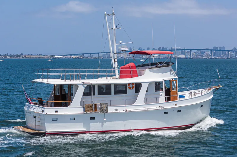 The Image of 1971 Grand Banks yacht cruising on blue water with city skyline in background. - 0