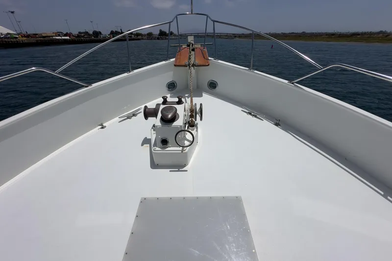 Slide: The Image of 1971 Grand Banks boat deck with anchor chain and winch, overlooking calm waters. - 10