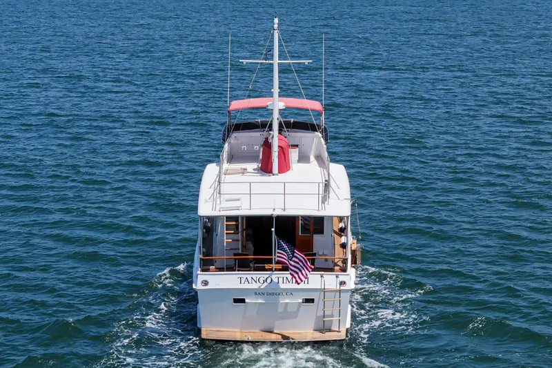 Slide: The Image of 1971 Grand Banks yacht cruising on open water with American flag. - 13
