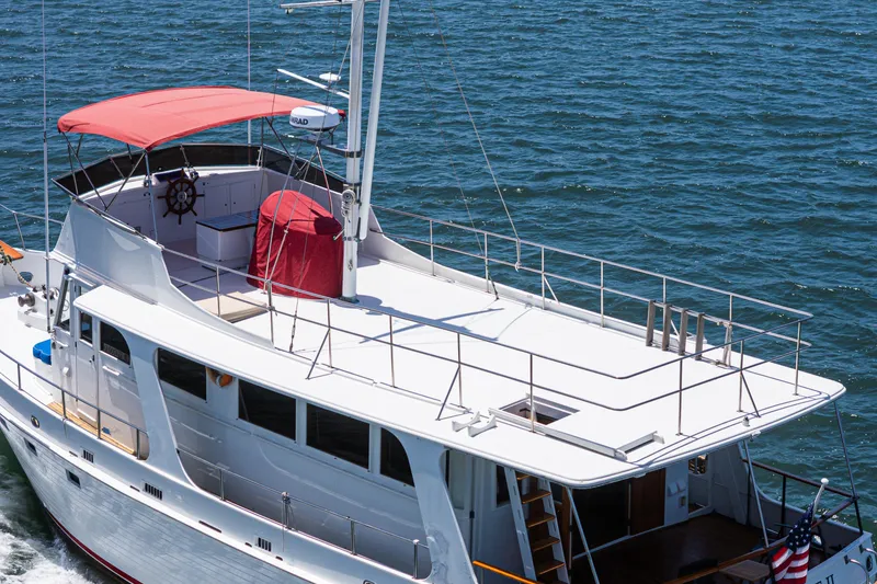 Slide: The Image of 1971 Grand Banks yacht with red canopy cruising on open water. - 14