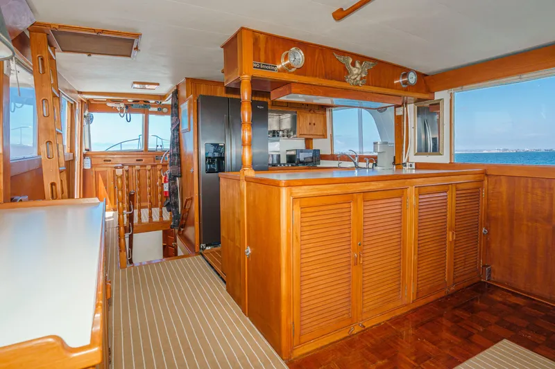 Slide: The Image of Interior of a 1971 Grand Banks boat featuring wooden cabinetry and ocean view. - 24