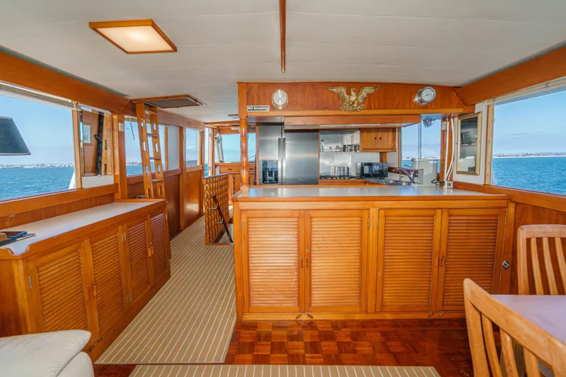 Slide: The Image of Interior of a 1971 Grand Banks boat with wooden cabinetry and ocean view. - 25