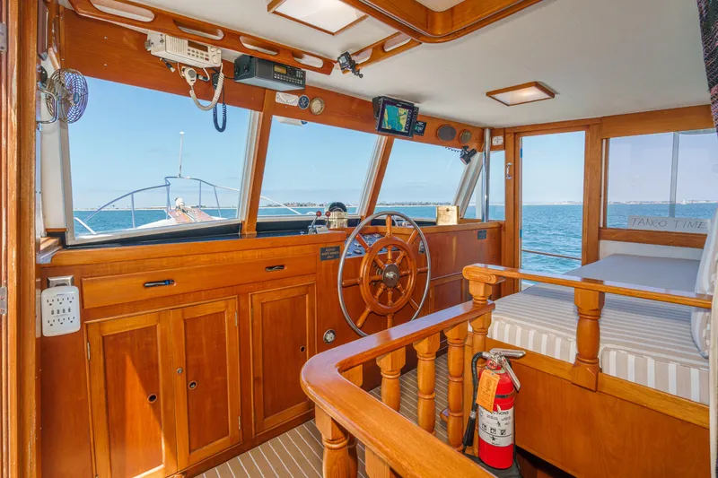 Slide: The Image of Interior of a 1971 Grand Banks boat with wooden helm and ocean view. - 3