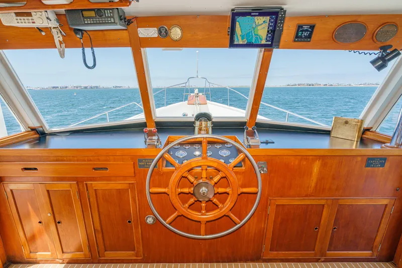 Slide: The Image of 1971 Grand Banks boat helm with wooden wheel, navigation instruments, and ocean view. - 31
