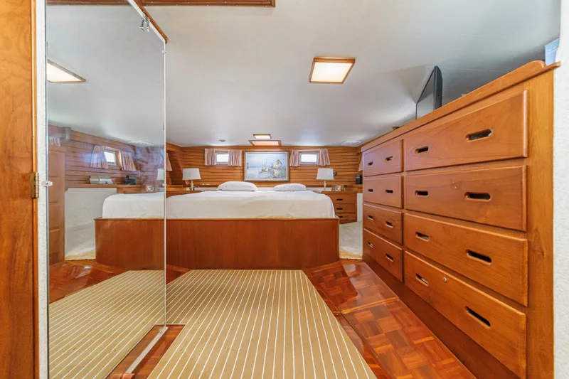 Slide: The Image of Luxurious 1971 Grand Banks yacht bedroom with wooden interior and ample storage. - 36