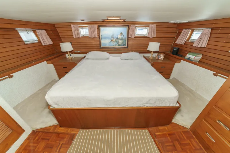 Slide: The Image of Cozy 1971 Grand Banks boat cabin with wood paneling and a comfortable bed. - 37