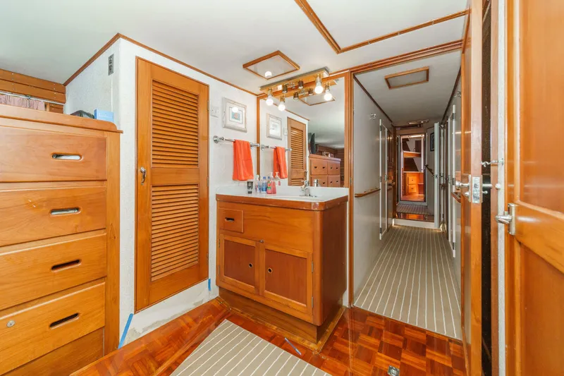 Slide: The Image of Interior of a 1971 Grand Banks boat featuring wooden cabinetry and a compact sink area. - 39