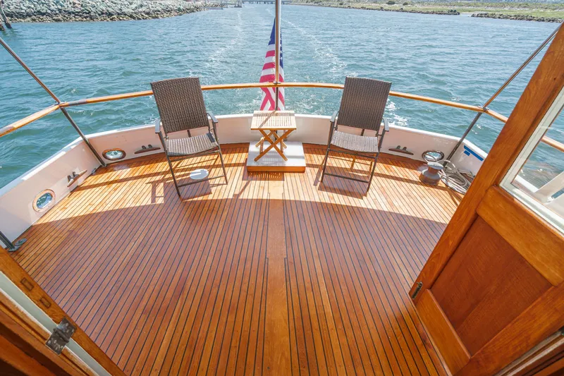 Slide: The Image of 1971 Grand Banks boat deck with chairs, table, and American flag on open water. - 4