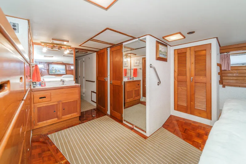 Slide: The Image of 1971 Grand Banks yacht interior with wooden cabinetry, mirrored closet, and cozy sleeping area. - 40