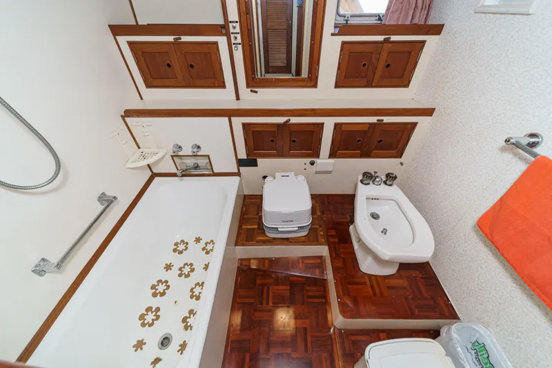 Slide: The Image of Vintage 1971 Grand Banks yacht bathroom with wooden cabinets, bathtub, and bidet. - 41