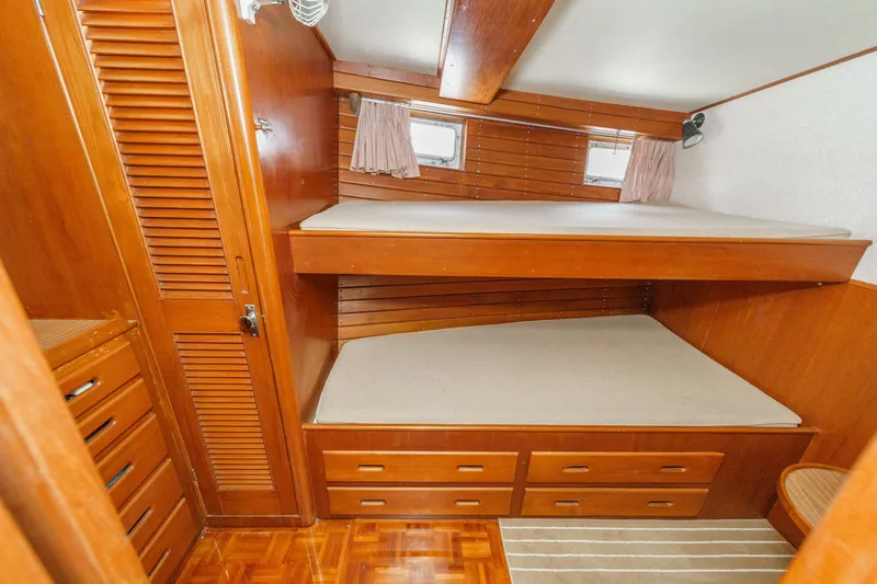 Slide: The Image of 1971 Grand Banks boat cabin with wooden bunk beds and storage drawers. - 43