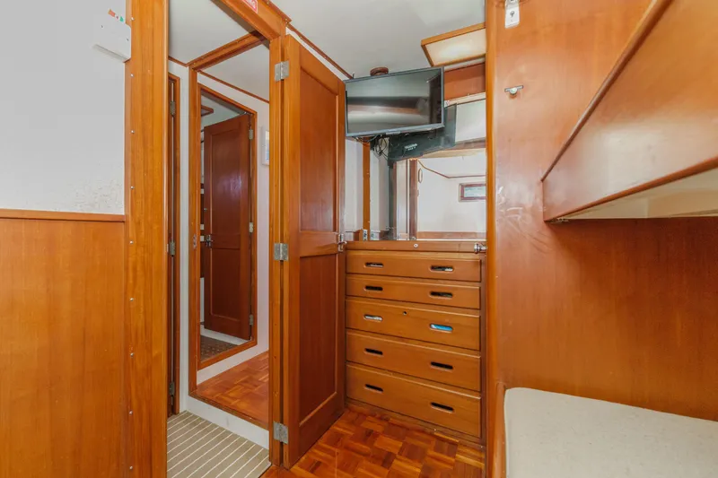 Slide: The Image of Interior of a 1971 Grand Banks boat with wooden cabinetry and a mounted TV. - 44