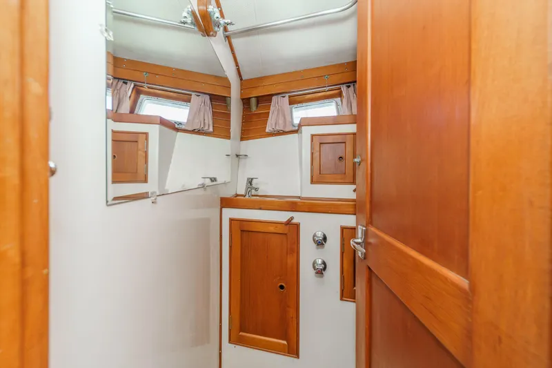 Slide: The Image of 1971 Grand Banks boat bathroom with wooden cabinetry and mirror. - 50