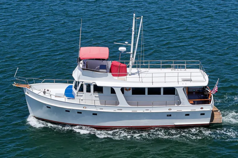 Slide: The Image of 1971 Grand Banks yacht cruising on open water with American flag. - 57