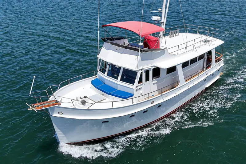 Slide: The Image of 1971 Grand Banks yacht cruising on open water with red canopy and blue accents. - 6