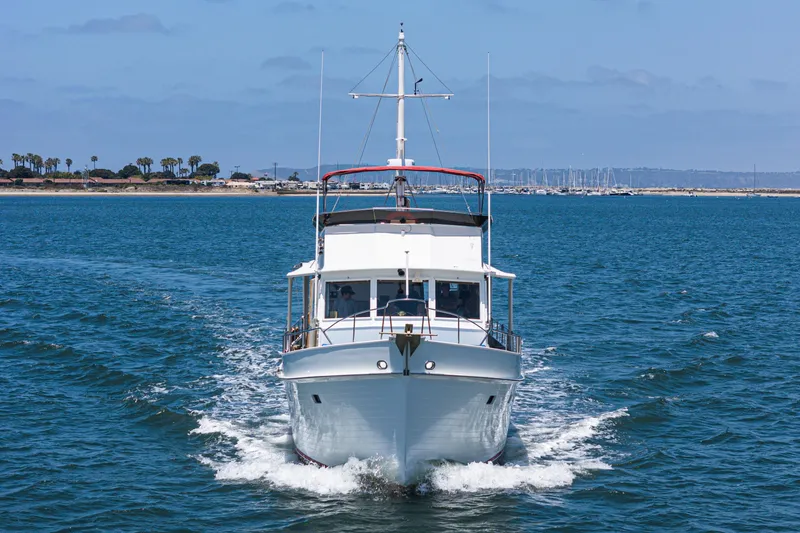 Slide: The Image of 1971 Grand Banks boat cruising on open water with coastal background. - 8