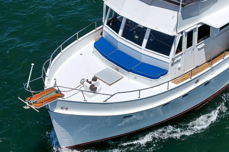 Slide: The Image of 1971 Grand Banks yacht cruising on open water with blue cushions and wooden deck. - 9