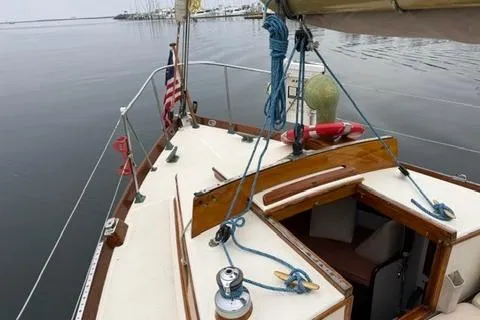Slide: The Image of 1962 Lapworth Sloop sailboat on calm water, featuring classic wooden deck and nautical equipment. - 11