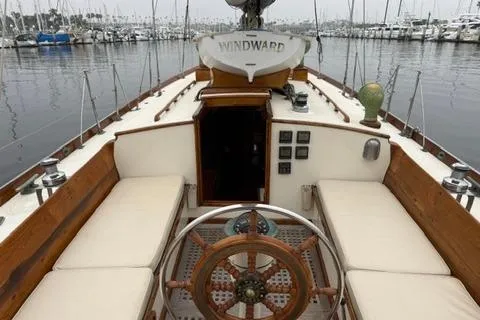 Slide: The Image of 1962 Lapworth Sloop sailboat with wooden deck and classic steering wheel in a marina. - 13