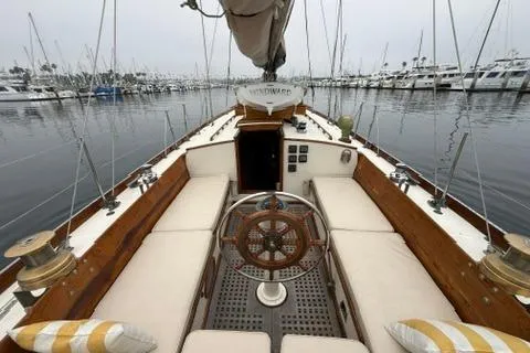 Slide: The Image of 1962 Lapworth Sloop sailboat interior with wooden helm, docked in a marina. - 14