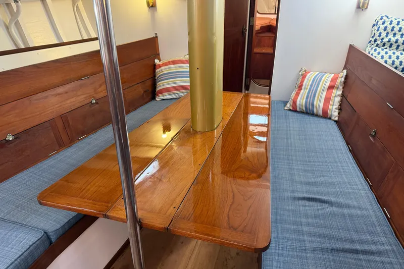 Slide: The Image of Interior of a 1962 Lapworth Sloop with polished wood table and blue cushioned seating. - 17