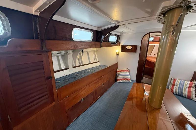Slide: The Image of Interior of a 1962 Lapworth Sloop, featuring wooden cabinetry and striped cushions. - 20