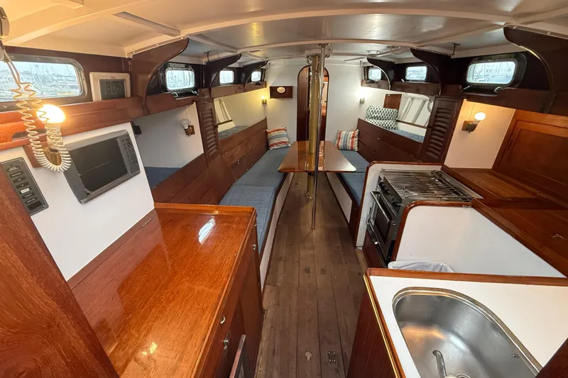 Slide: The Image of Interior of a 1962 Lapworth Sloop, featuring wood finishes and a compact kitchen area. - 22