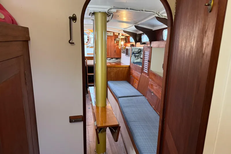 Slide: The Image of Interior of a 1962 Lapworth Sloop, featuring wooden furnishings and cozy seating. - 23