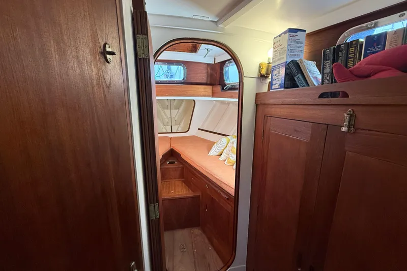 Slide: The Image of Interior of a 1962 Lapworth Sloop, featuring cozy wooden cabin and bookshelf. - 24