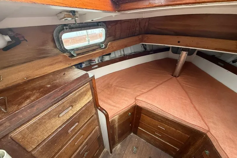 Slide: The Image of Interior of a 1962 Lapworth Sloop, featuring wooden cabinetry and cozy sleeping area. - 27