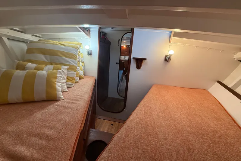 Slide: The Image of Cozy 1962 Lapworth Sloop cabin interior with striped pillows and warm lighting. - 29