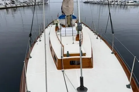 Slide: The Image of 1962 Lapworth Sloop sailboat docked in a marina, showcasing its classic design and wooden details. - 3
