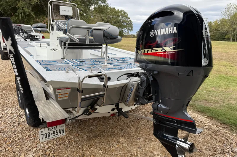 Slide: The Image of 2023 Xpress H22B Bay boat with Yamaha VMAX engine, parked on gravel. - 4