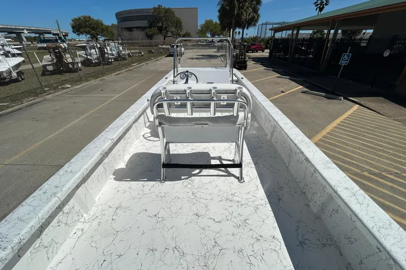 Slide: The Image of 2026 Coastal Skiff 271 boat with marble-patterned deck, parked outdoors under clear skies. - 10