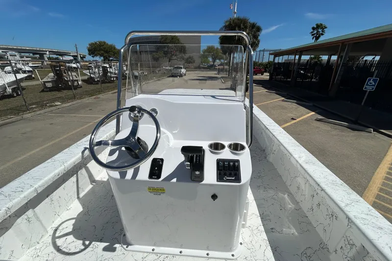 Slide: The Image of 2026 Coastal Skiff 271 boat console with steering wheel and controls, parked outdoors. - 12