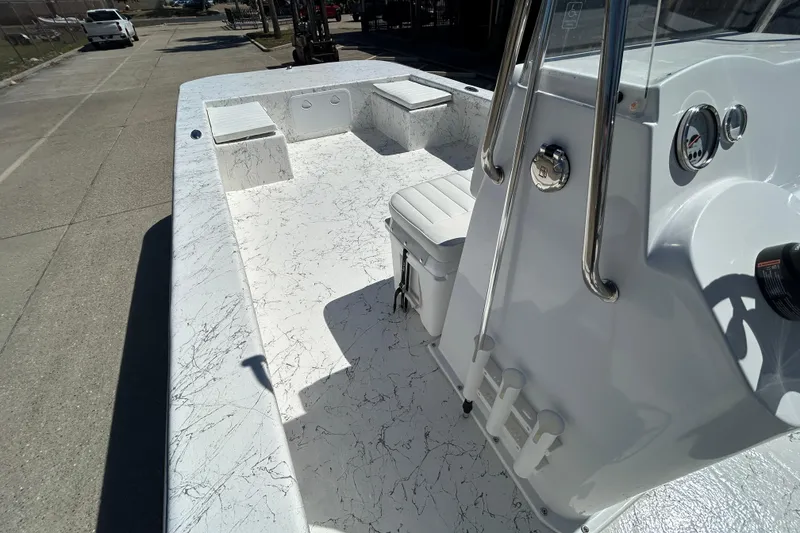 Slide: The Image of 2026 Coastal Skiff 271 boat interior with white seating and console, parked on a street. - 14