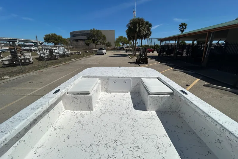Slide: The Image of 2026 Coastal Skiff 271 boat with marble-patterned deck, parked in a marina under clear blue skies. - 15
