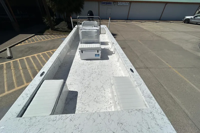 Slide: The Image of 2026 Coastal Skiff 271 boat with spacious deck and seating, parked in a lot. - 18