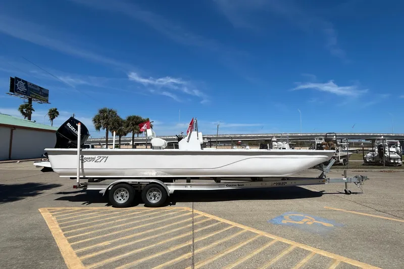 Slide: The Image of 2026 Coastal Skiff 271 boat on trailer under clear blue sky. - 5