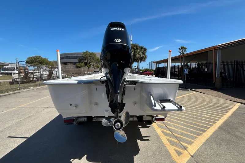 Slide: The Image of 2026 Coastal Skiff 271 boat with powerful outboard motor in a sunny marina setting. - 7