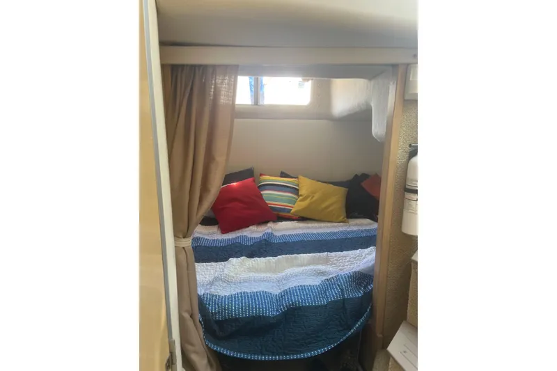 Slide: The Image of Cozy cabin interior of 2001 Maxum 3300 SCR with colorful pillows and quilted bedding. - 12